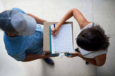Buy stock photo High angle shot of a businesswoman signing for her package from the courier