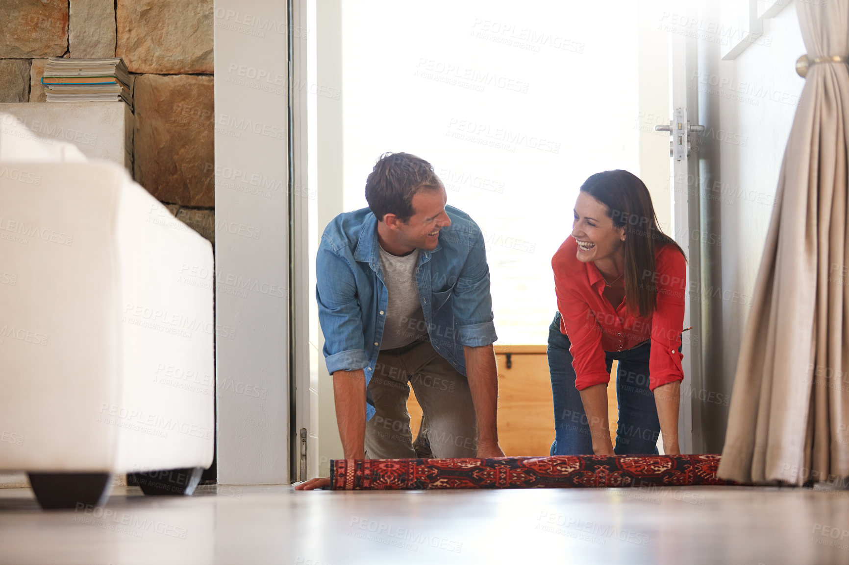 Buy stock photo Shot of a mature couple rolling out a carpet together at home