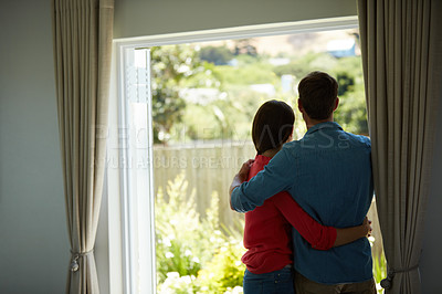 Buy stock photo Rear view shot of a mature couple looking out the window at home together