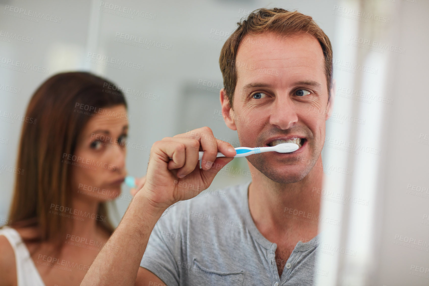 Buy stock photo Shot of a mature couple brushing their teeth together in the bathroom