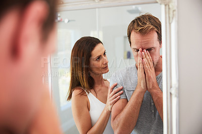 Buy stock photo Shot of a woman comforting her distraught husband at home