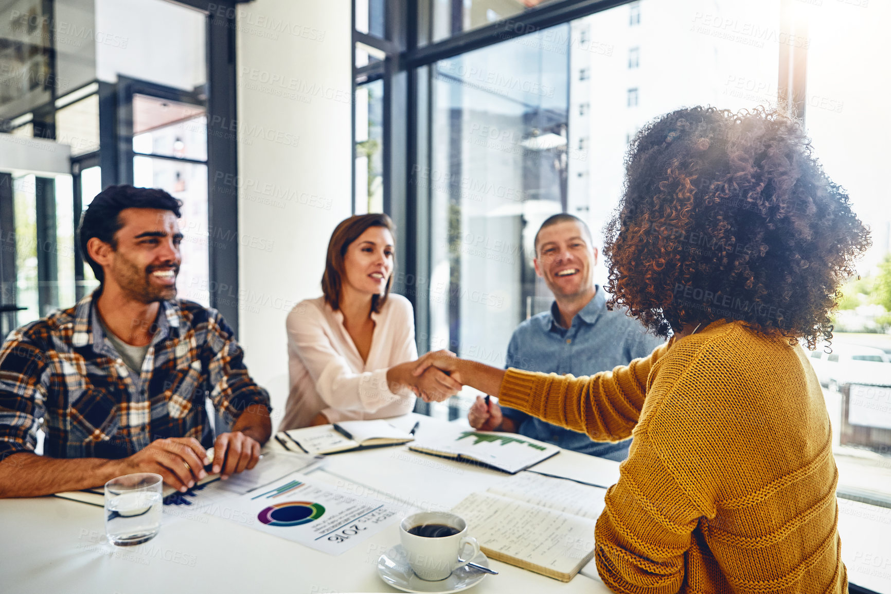 Buy stock photo Cropped shot of two designers shaking hands during a meeting in an office