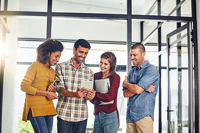 Buy stock photo Cropped shot of a team of designers working together on a digital tablet in an office