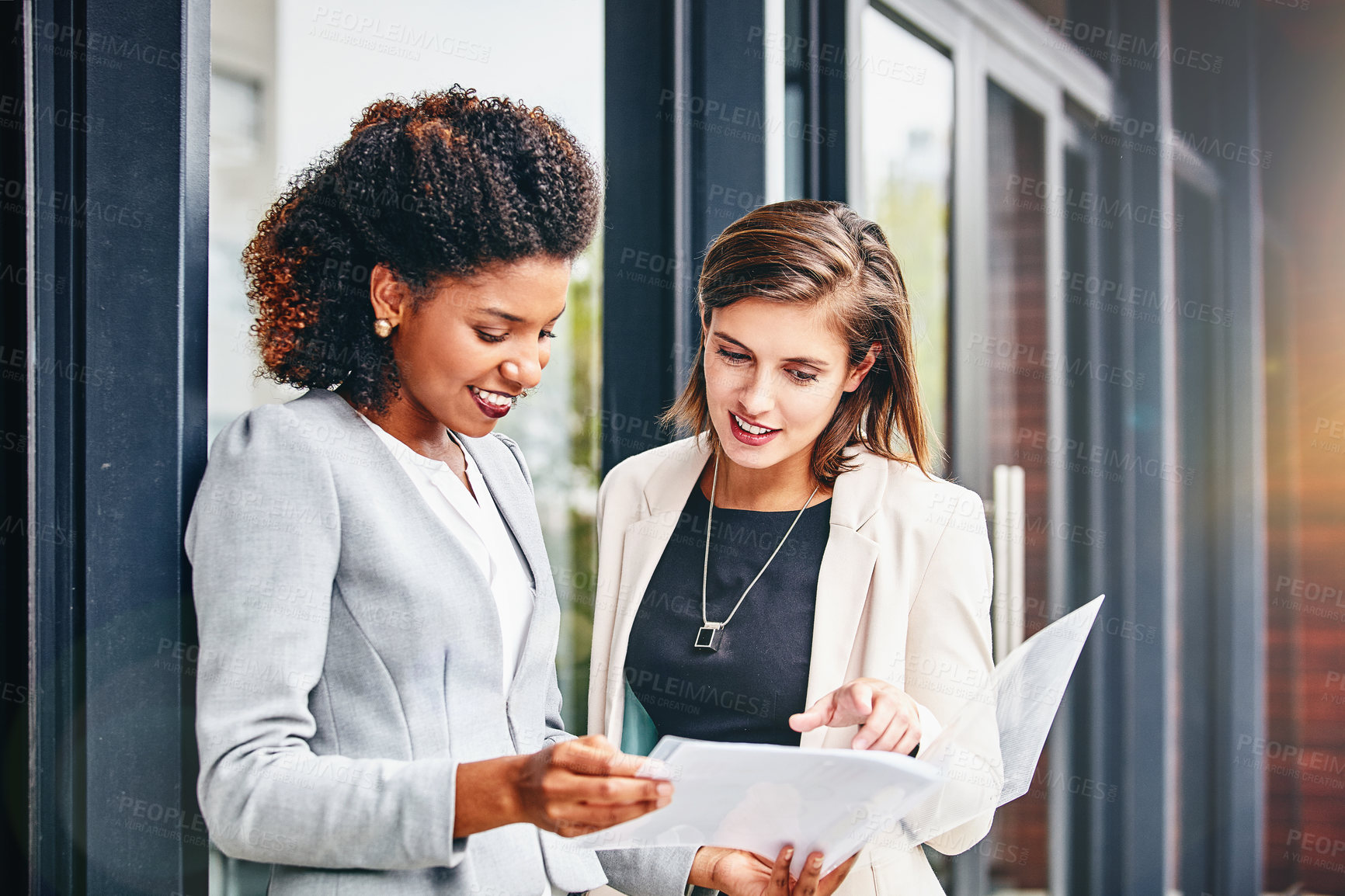 Buy stock photo Cropped shot of two businesswomen having a discussion outside an office