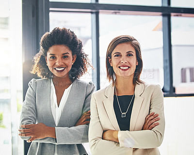 Buy stock photo Portrait of two confident young businesswomen standing together in an office