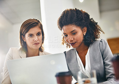 Buy stock photo Cropped shot of two businesswomen working together on a laptop in an office