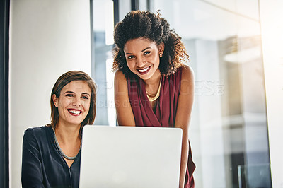 Buy stock photo Portrait of two businesswomen working together on a laptop in an office