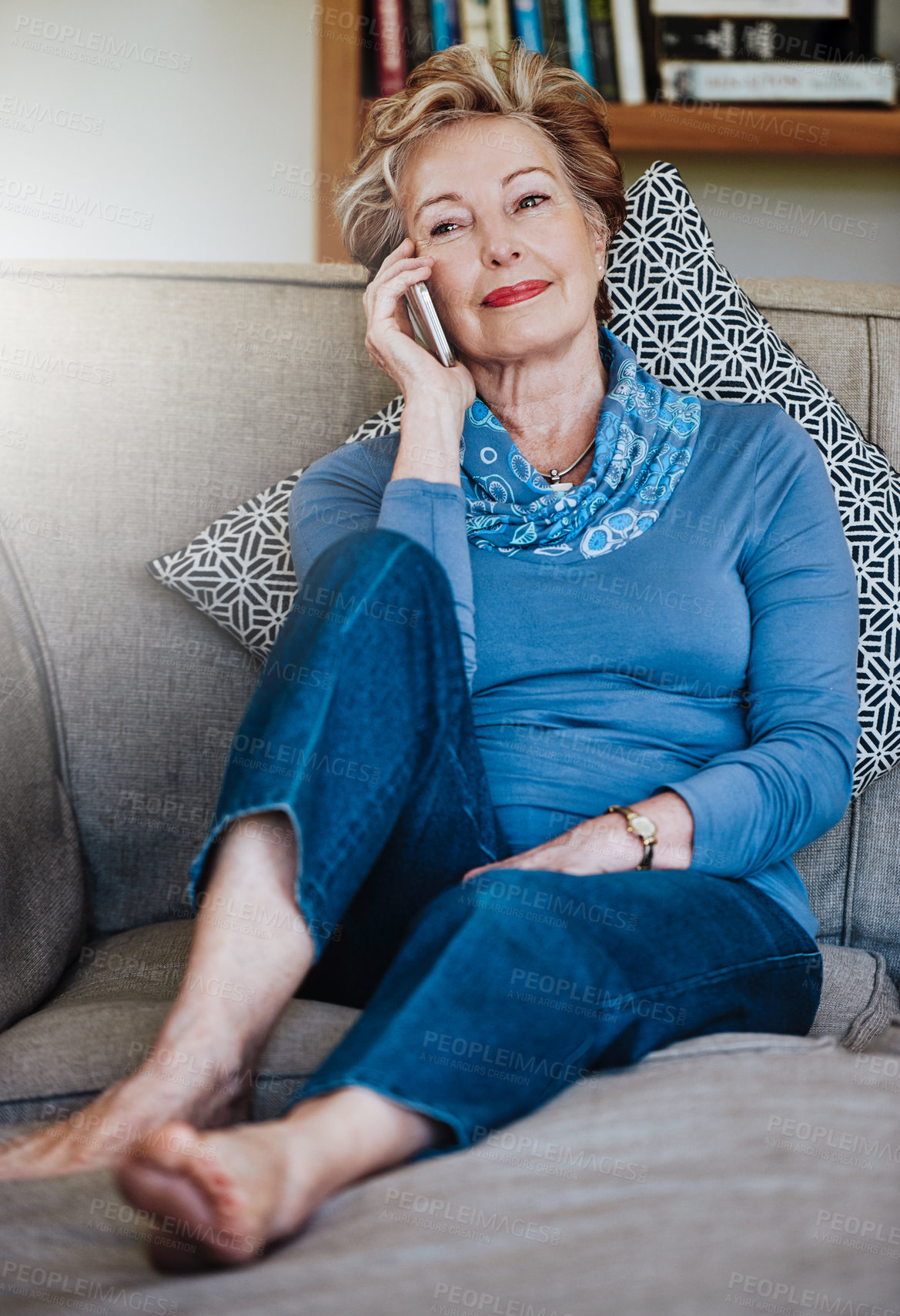 Buy stock photo Shot of a relaxed senior woman using a phone at home on the sofa