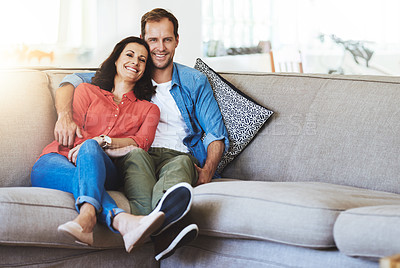 Buy stock photo Full length portrait of an affectionate couple sitting on the sofa at home