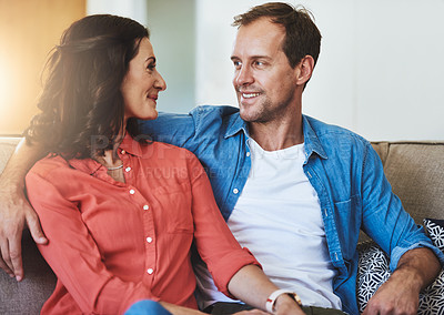 Buy stock photo Cropped shot of an affectionate couple sitting on the sofa at home