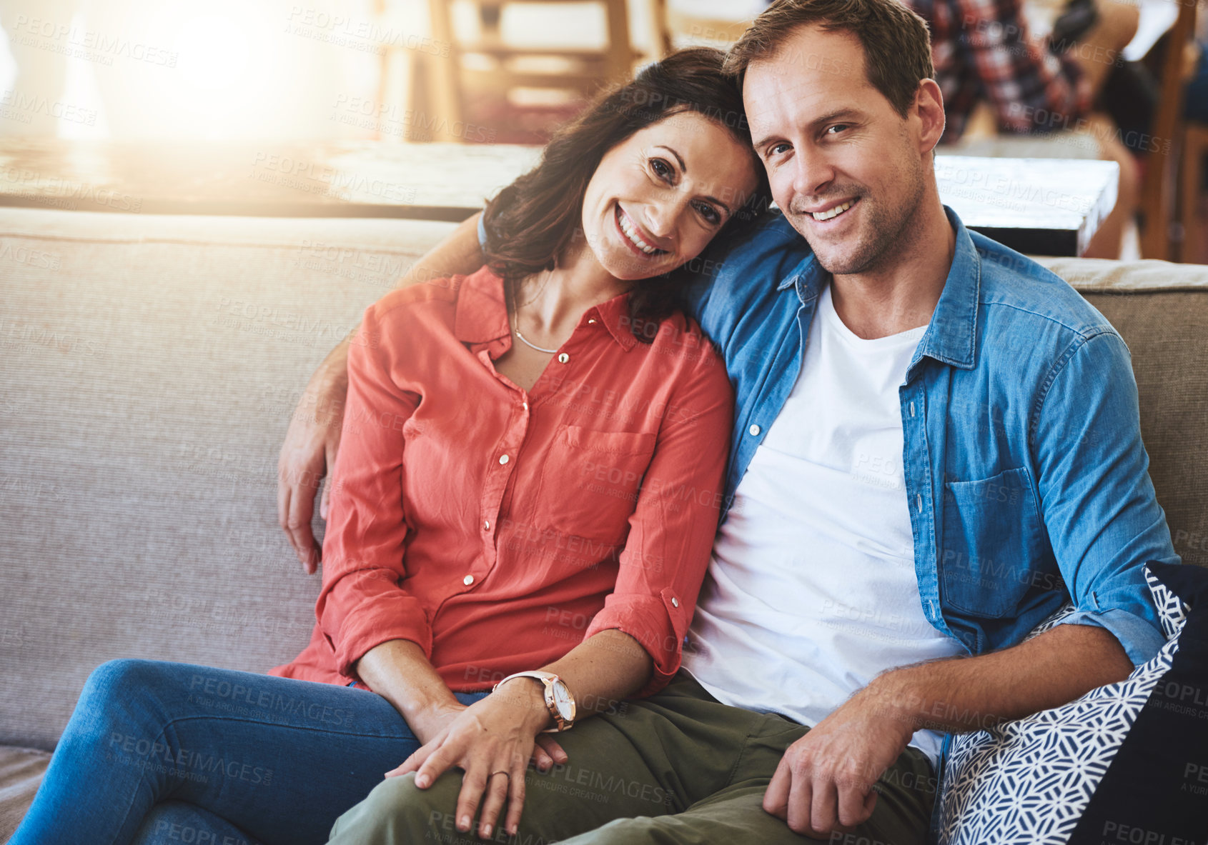 Buy stock photo Cropped portrait of an affectionate couple sitting on the sofa at home