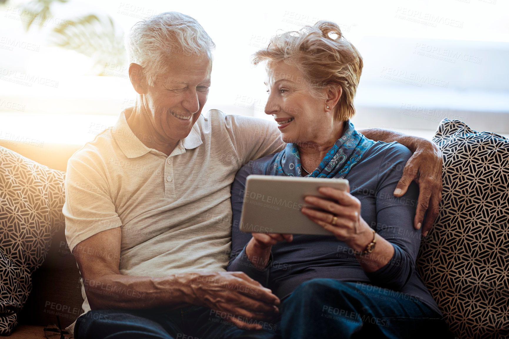 Buy stock photo Mature couple, tablet and watch in living room, digital and online for news, information and show on app. Conversation, man and woman with smile in lounge of home, relax and download of movie