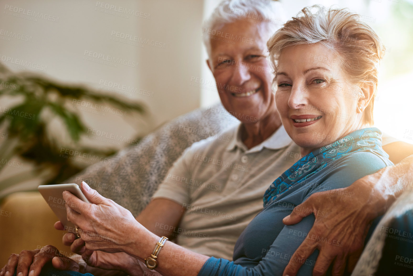 Buy stock photo Portrait of a happy senior couple using a digital tablet together on the sofa at home