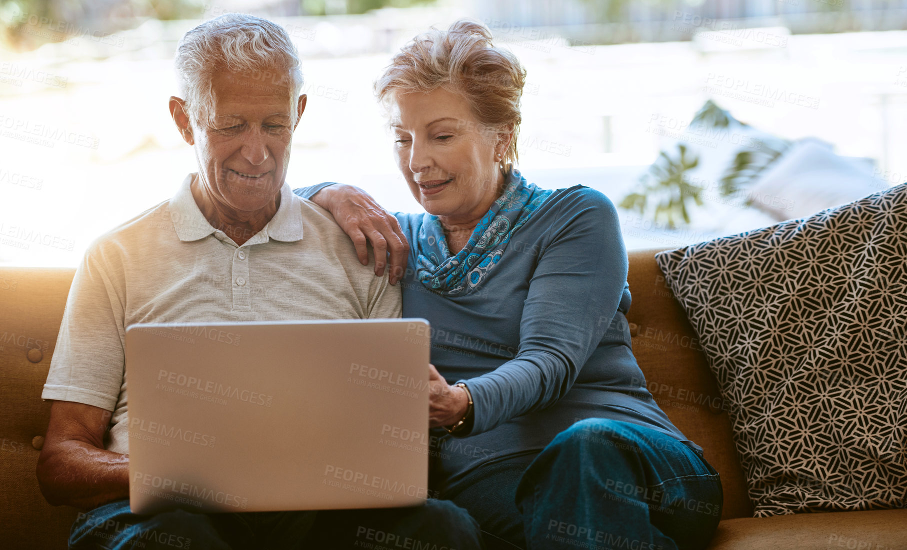 Buy stock photo Shot of a happy senior couple using a laptop together on the sofa at home