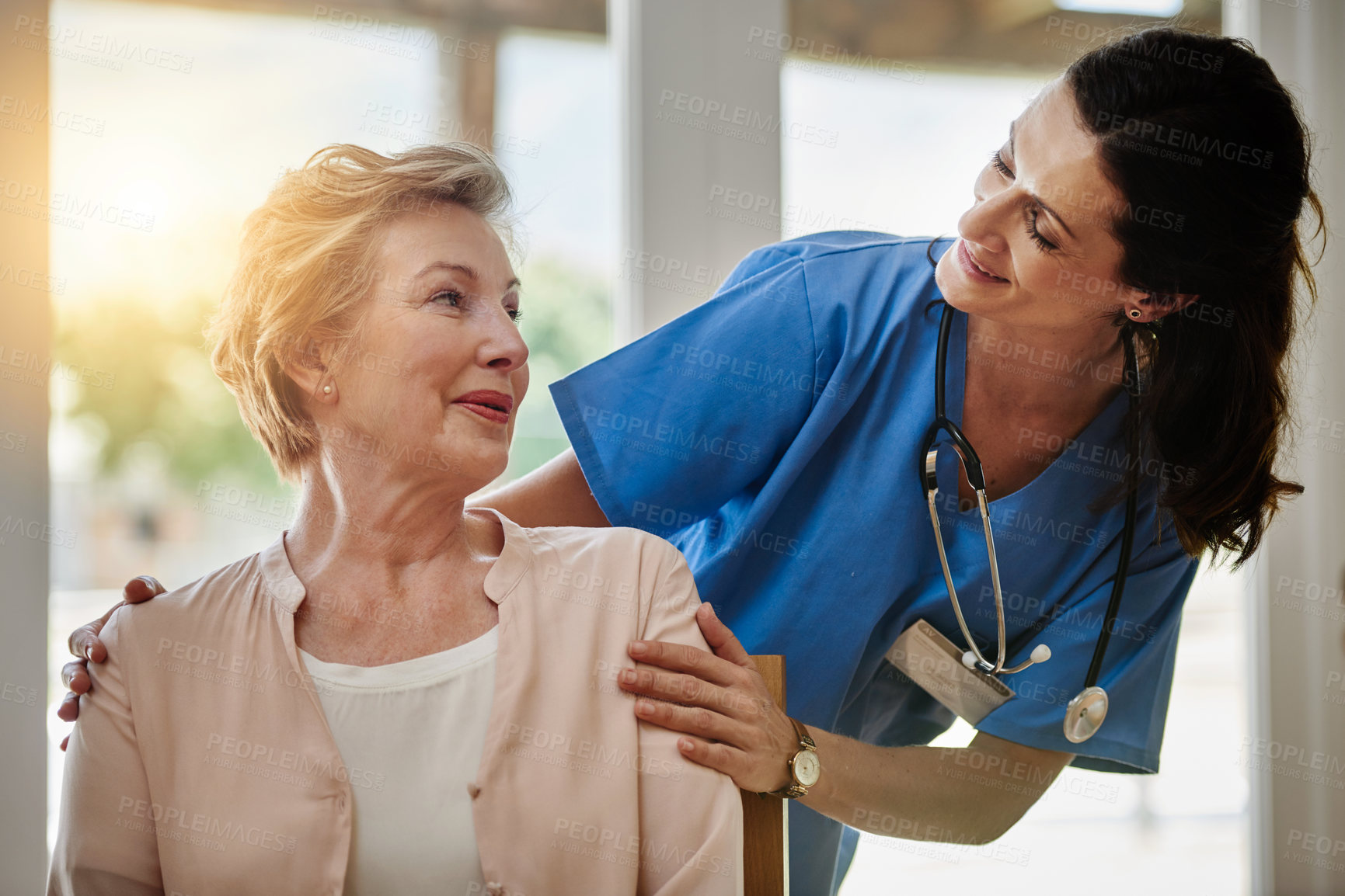 Buy stock photo Shot of a smiling senior woman talking with a nurse in assisted living facility