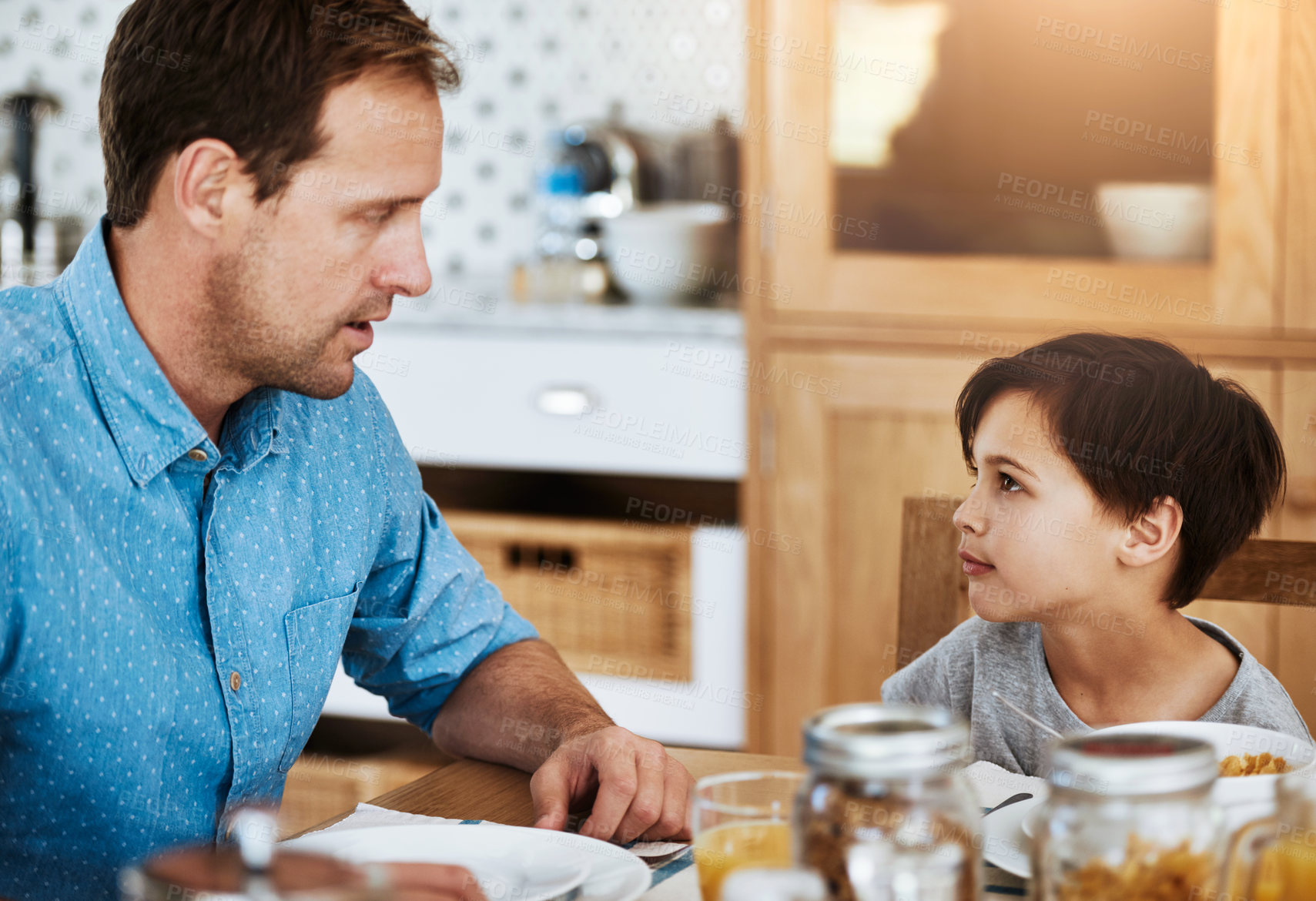 Buy stock photo Cropped shot of a father and his little son having breakfast together at home