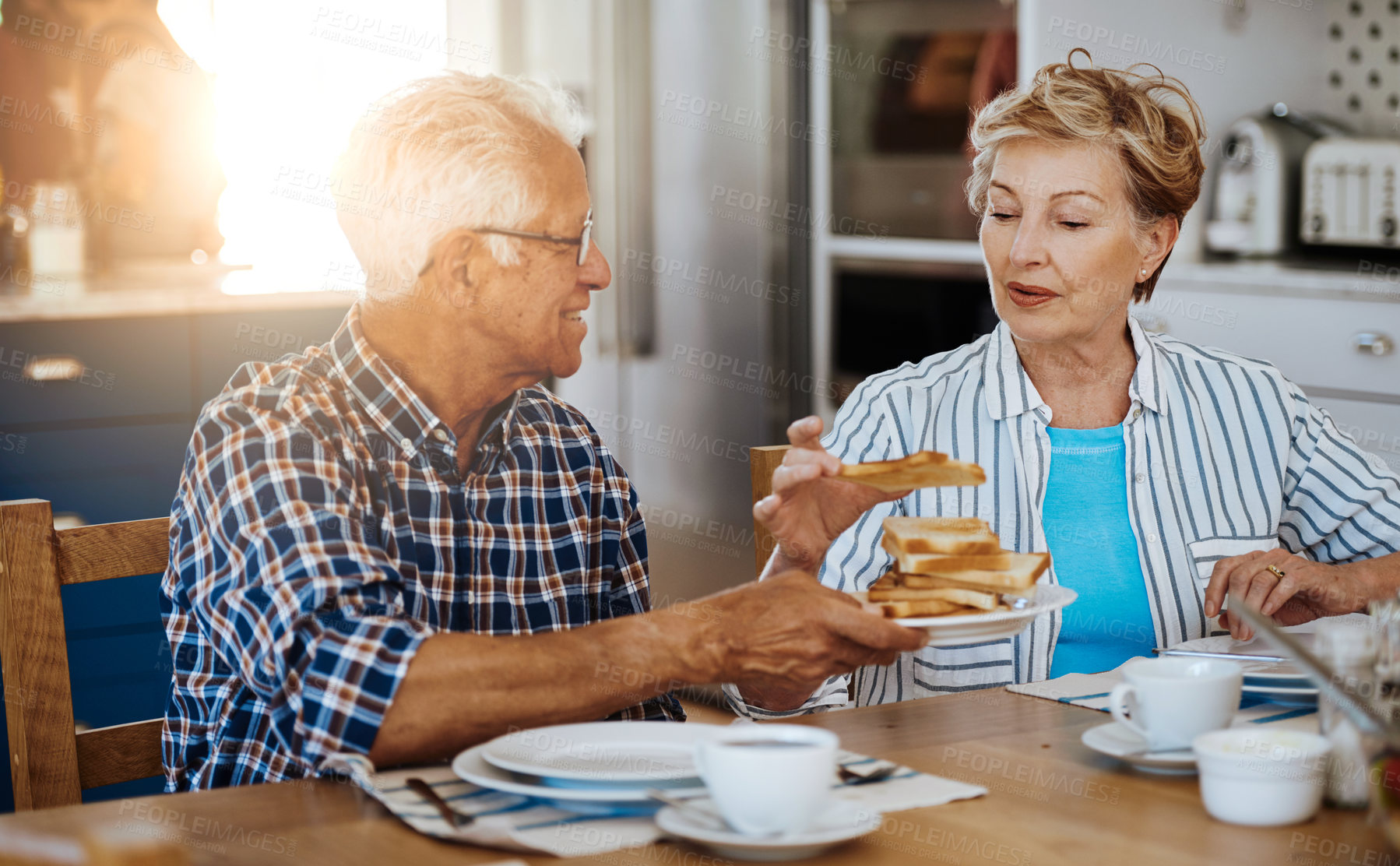 Buy stock photo Cropped shot of a senior couple having breakfast together at home