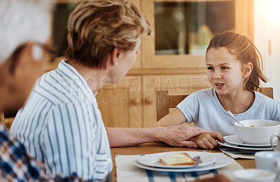 Buy stock photo Cropped shot of a little girl having breakfast with her grandmother at home