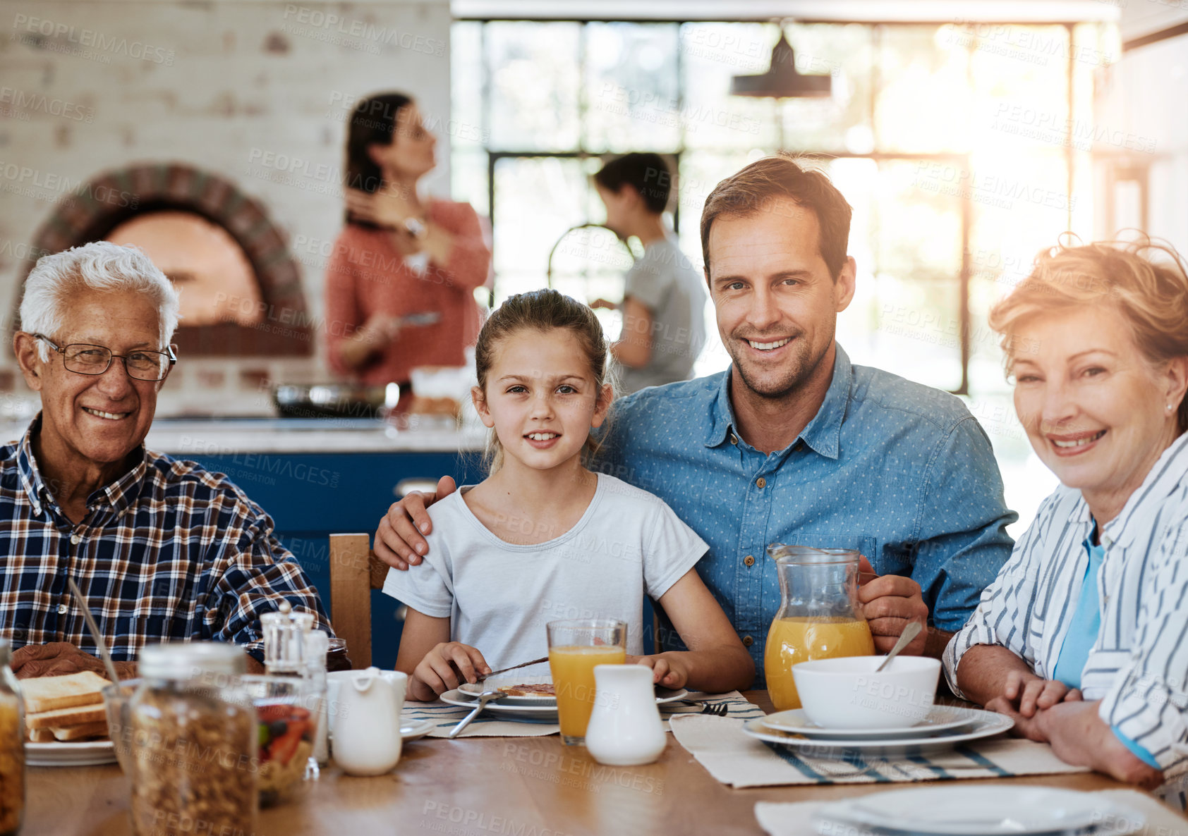 Buy stock photo Portrait of a multi generational family enjoying breakfast together at home