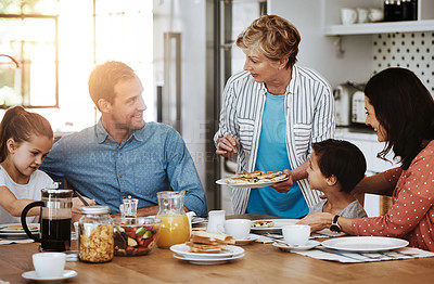 Buy stock photo Cropped shot of a multi generational family enjoying breakfast together at home