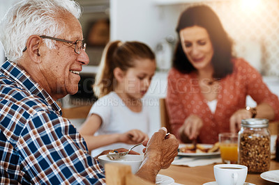 Buy stock photo Cropped shot of an elderly man enjoying breakfast with his family at home