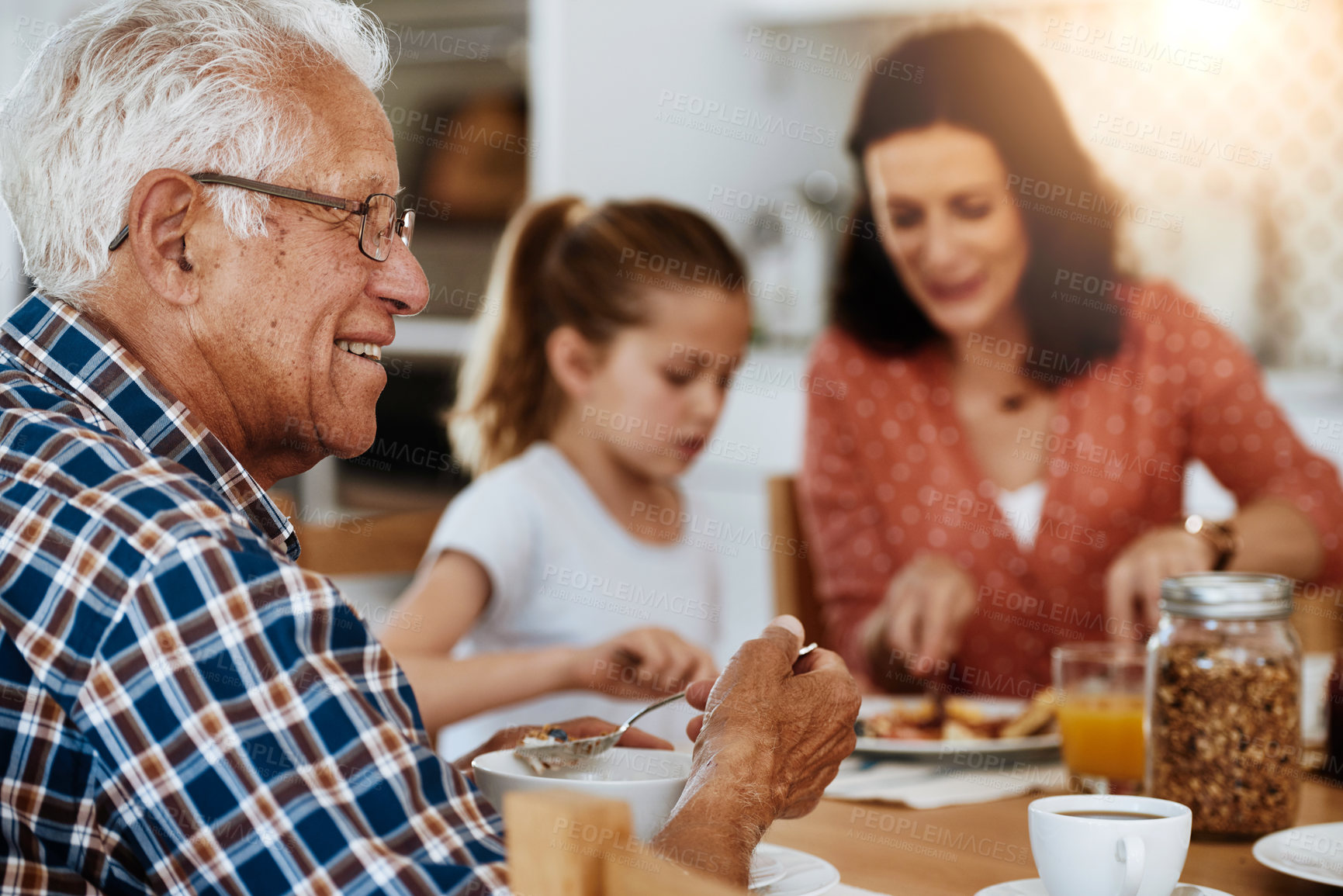 Buy stock photo Cropped shot of an elderly man enjoying breakfast with his family at home