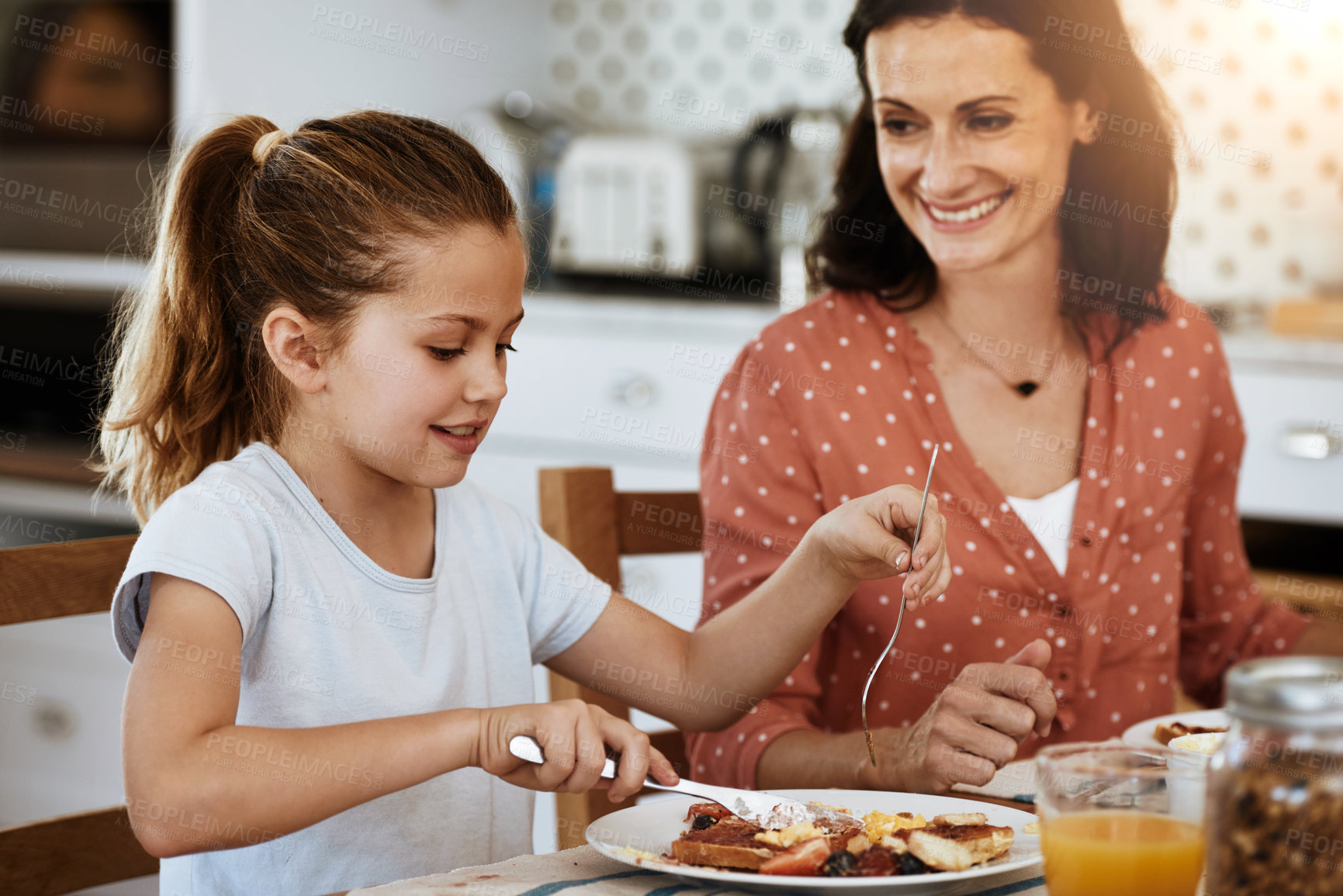 Buy stock photo Cropped shot of a mother and her little daughter having breakfast together at home