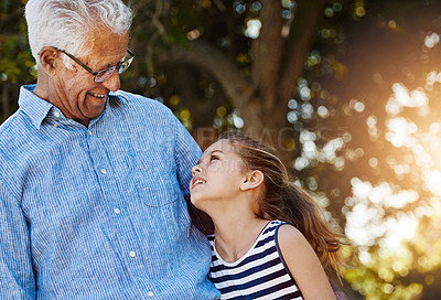 Buy stock photo Shot of a cute little girl spending time outside with her grandfather