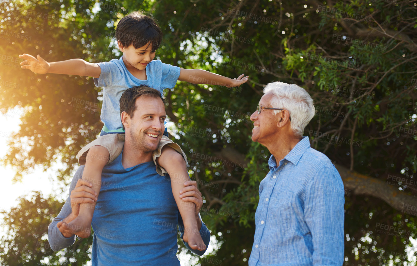 Buy stock photo Portrait of a young boy spending quality time outside with his father and grandfather