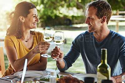 Buy stock photo Shot of a happy married couple enjoying lunch together outside