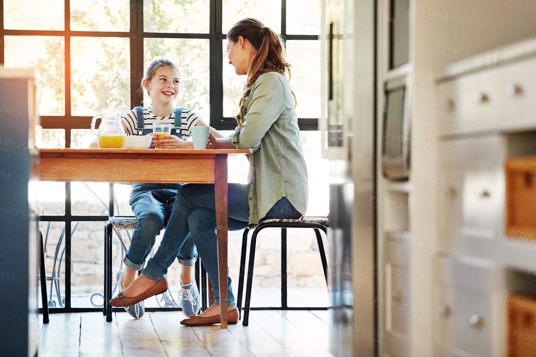 Buy stock photo Shot of a happy mother and daughter enjoying breakfast together at home