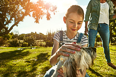 Buy stock photo Shot of a little girl and her mother playing with their dog at the park