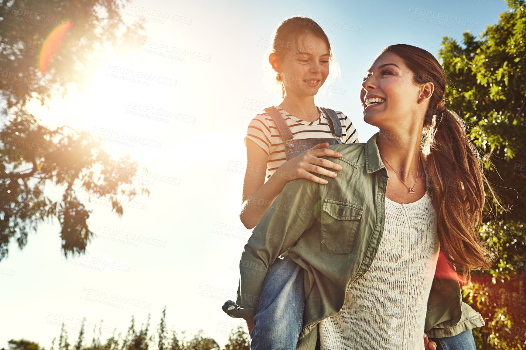 Buy stock photo Sunshine, mom and child with piggyback in outdoor park for game, fun and bonding together. Nature, playing and happy mother with young girl on back for support, summer vacation or weekend in Indiana
