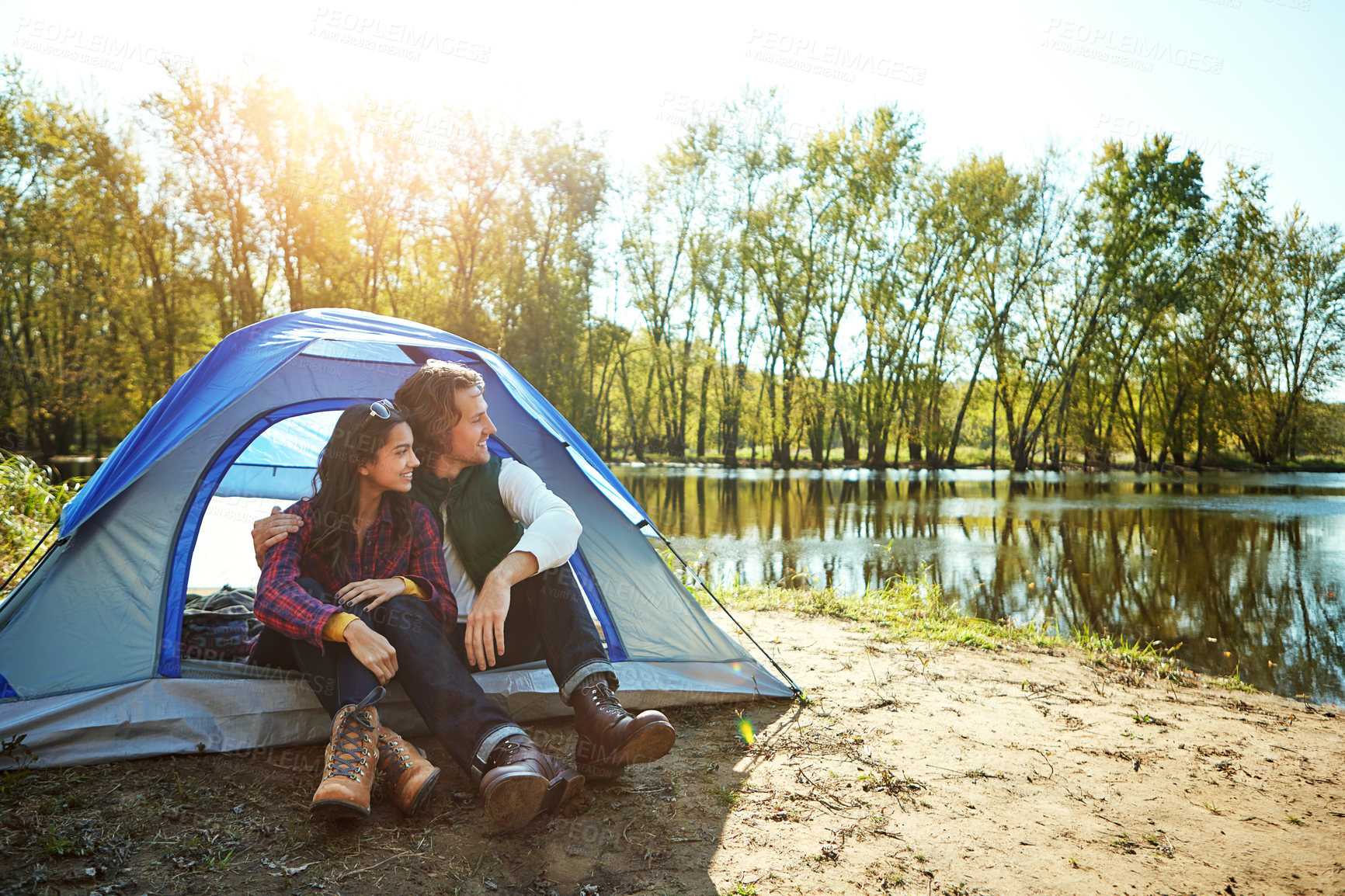 Buy stock photo River, camping and couple relax in tent with love and happiness together on adventure in woods. People, hug or embrace outdoor in nature thinking of vacation or travel to lake in forest with peace