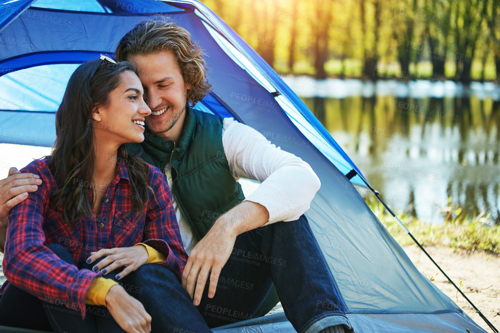 Buy stock photo Camping, couple and hug in tent with love and happiness together on adventure in woods at lake. People, embrace or relax outdoor in countryside with peace on vacation or travel to river in forest