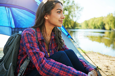 Buy stock photo Cropped shot of an attractive young woman sitting at her campsite