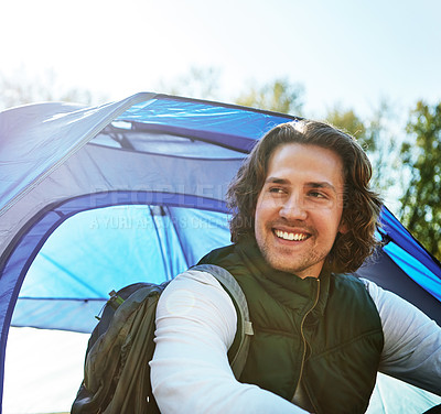 Buy stock photo Cropped shot of a handsome young man sitting at his campsite