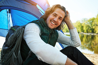 Buy stock photo Cropped shot of a handsome young man sitting at his campsite