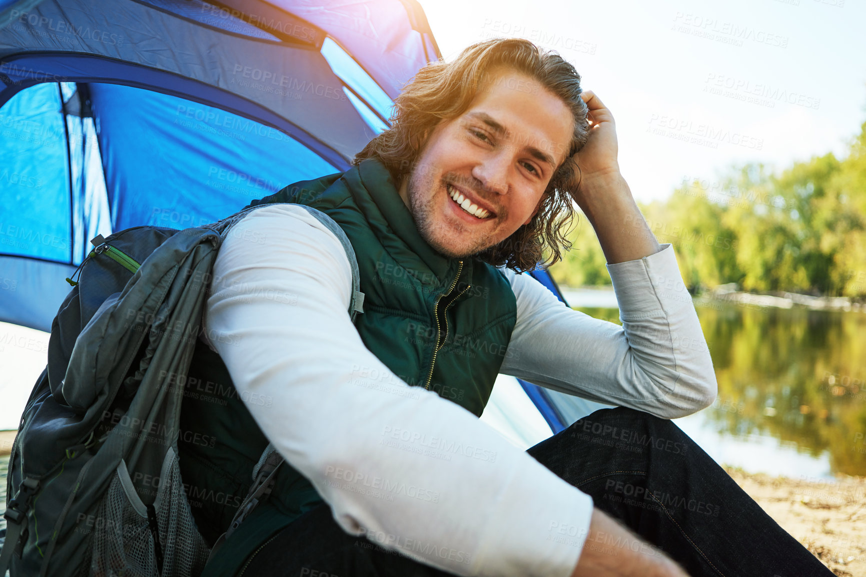 Buy stock photo Cropped shot of a handsome young man sitting at his campsite