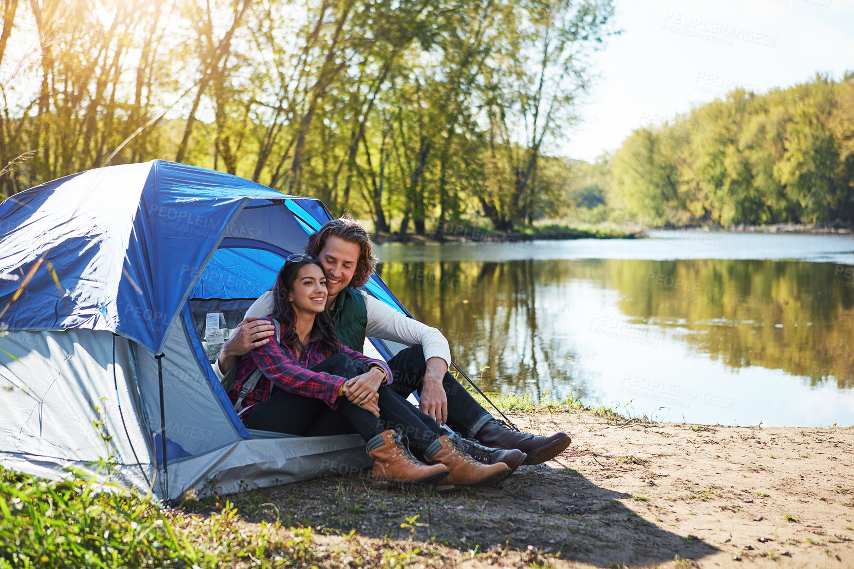 Buy stock photo Shot of an adventurous young couple at their campsite