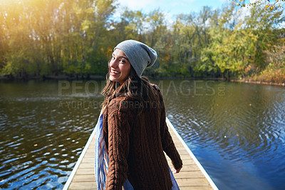 Buy stock photo Portrait of a happy young woman standing on a pier next to a lake