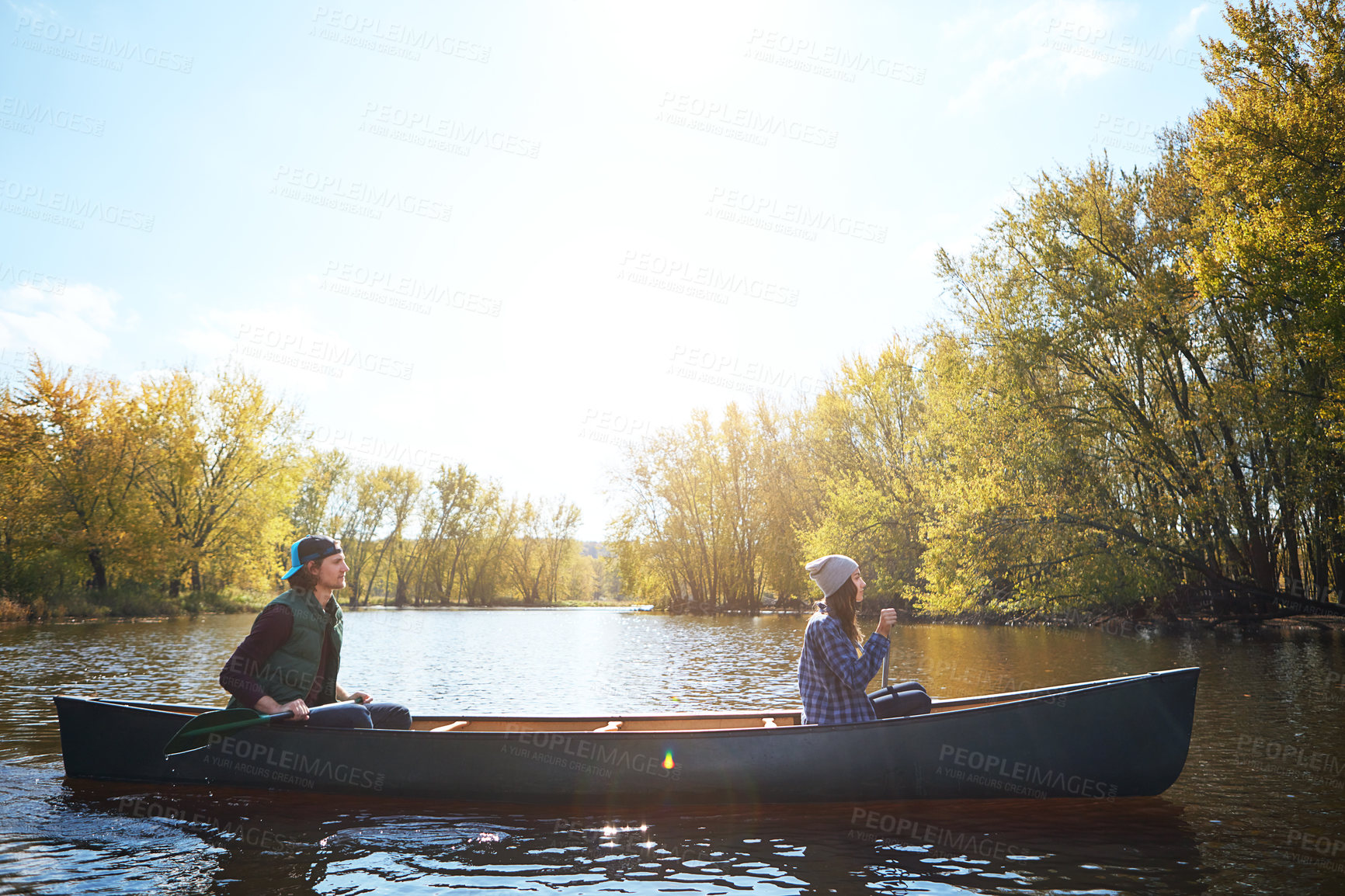 Buy stock photo Couple, river and canoeing for forest travel at holiday camp site for relax journey, explore or adventure. Man, woman and rowing teamwork on lake in Colorado for weekend vacation, morning or autumn