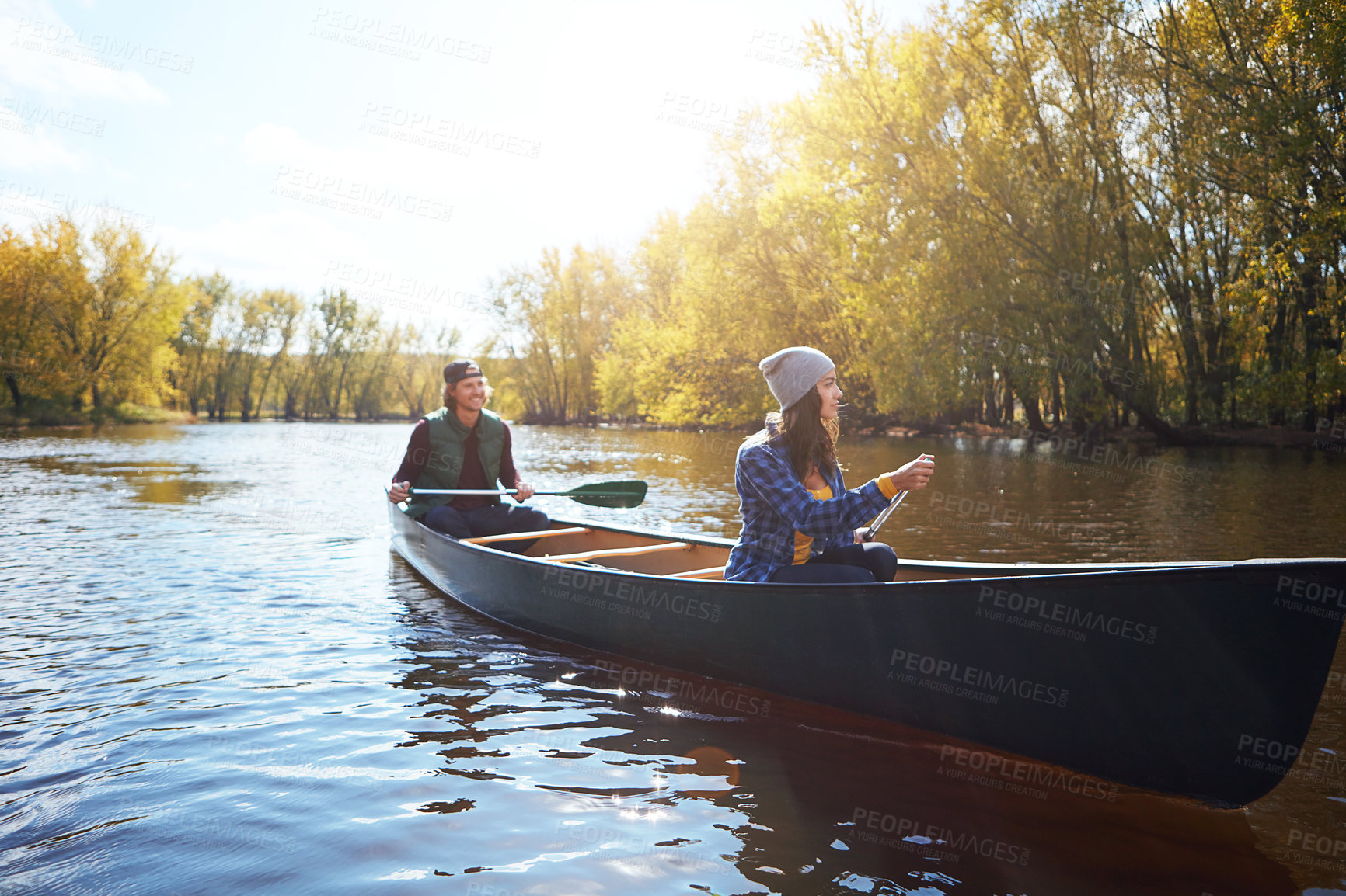 Buy stock photo Shot of a young couple going for a canoe ride on the lake