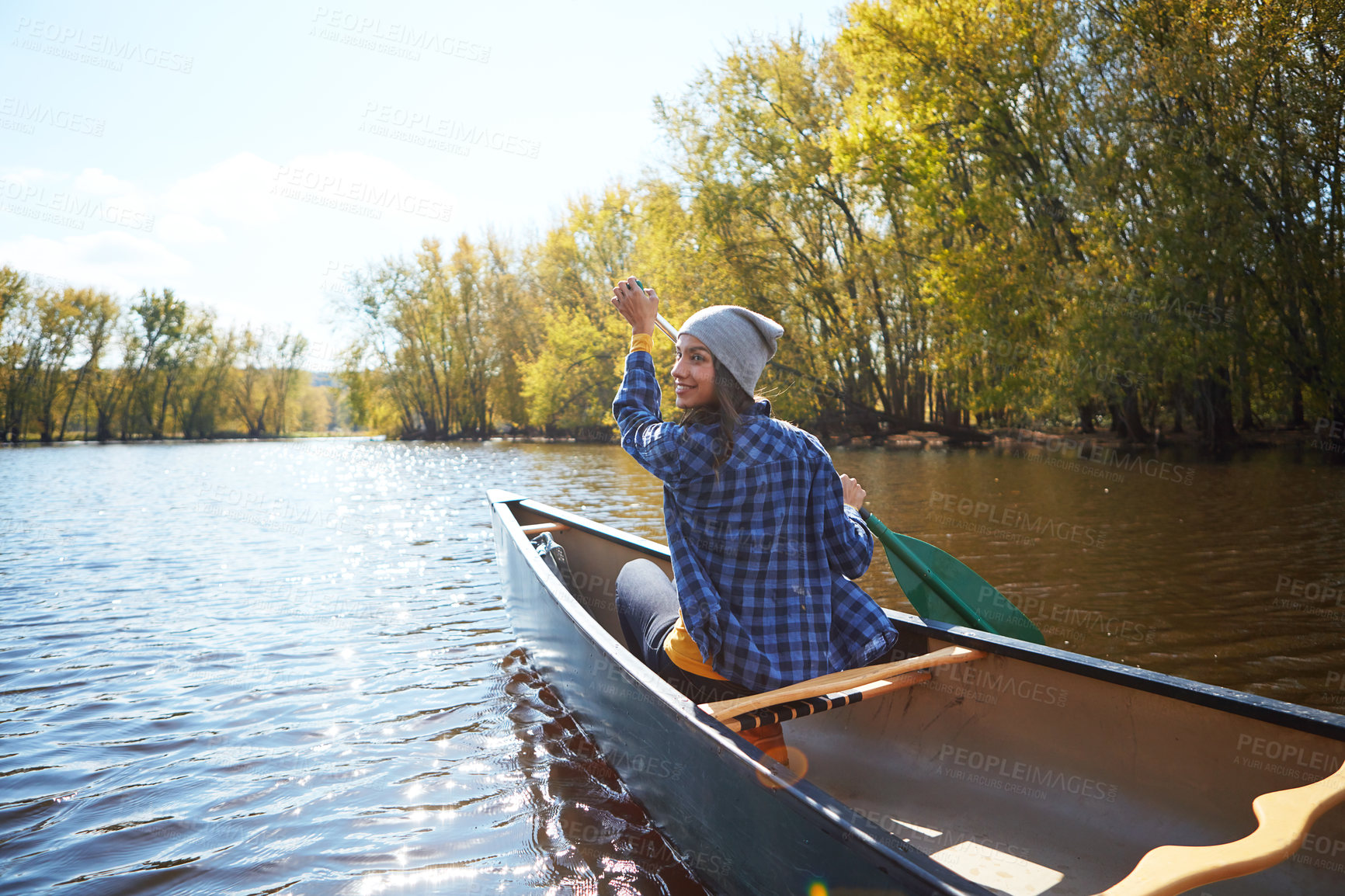 Buy stock photo Shot of a young woman enjoying her canoe ride on the lake