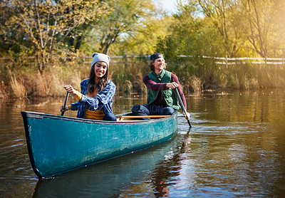 Buy stock photo Shot of a young couple going for a canoe ride on the lake