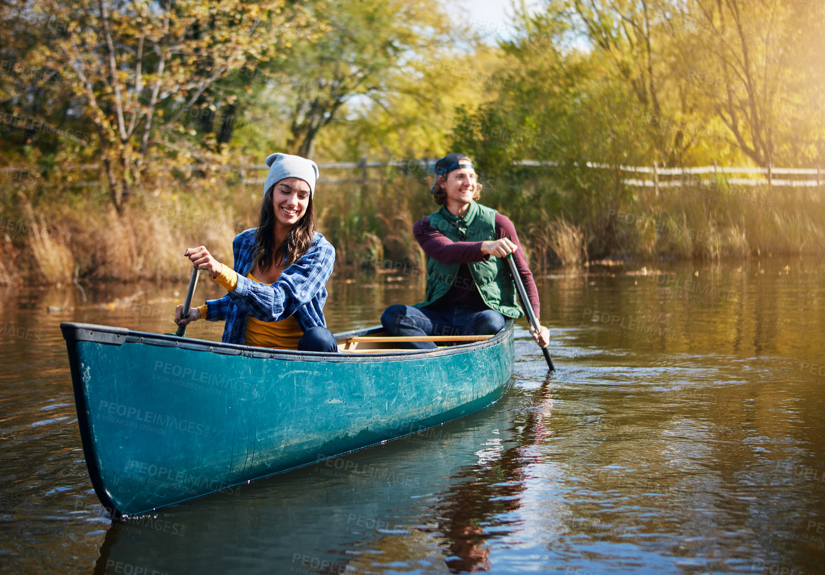 Buy stock photo Shot of a young couple going for a canoe ride on the lake