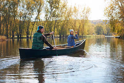 Buy stock photo Shot of a young couple going for a canoe ride on the lake