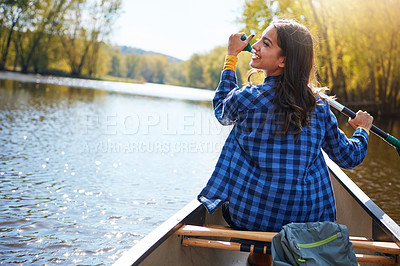 Buy stock photo Shot of a young woman going for a canoe ride on the lake