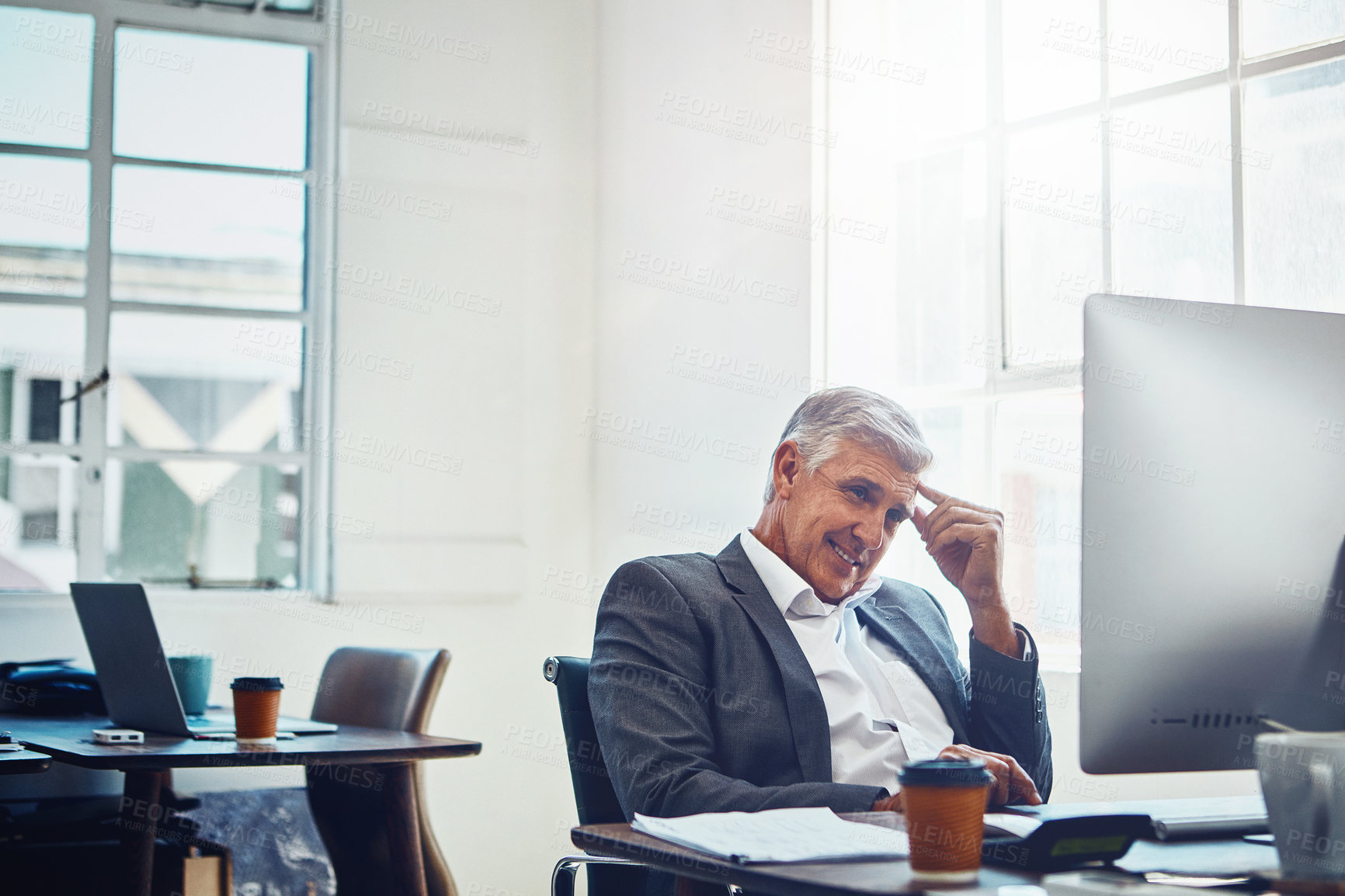 Buy stock photo Shot of a mature businessman working on a computer in an office