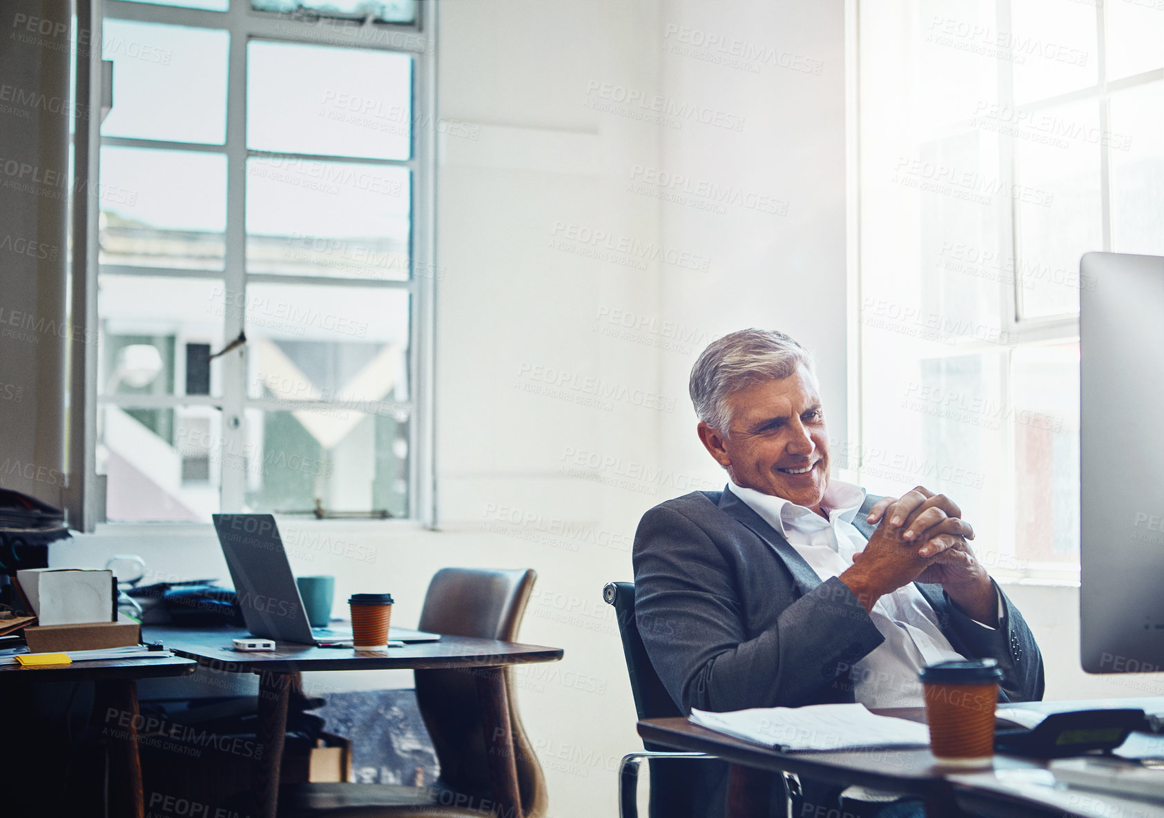 Buy stock photo Shot of a mature businessman working on a computer in an office